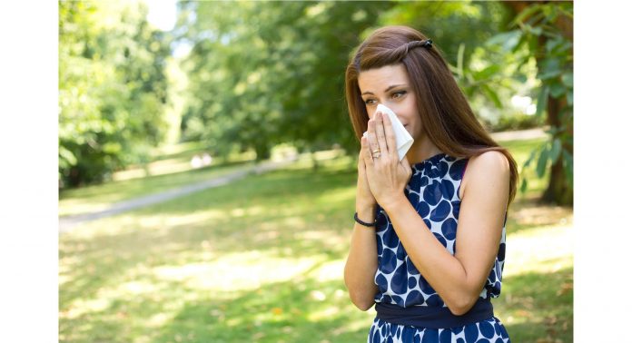Frau putzt sich die Nase im Sommer, Sommergrippe-natürlich-behandeln